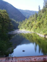 Butte County river with green trees lining the way