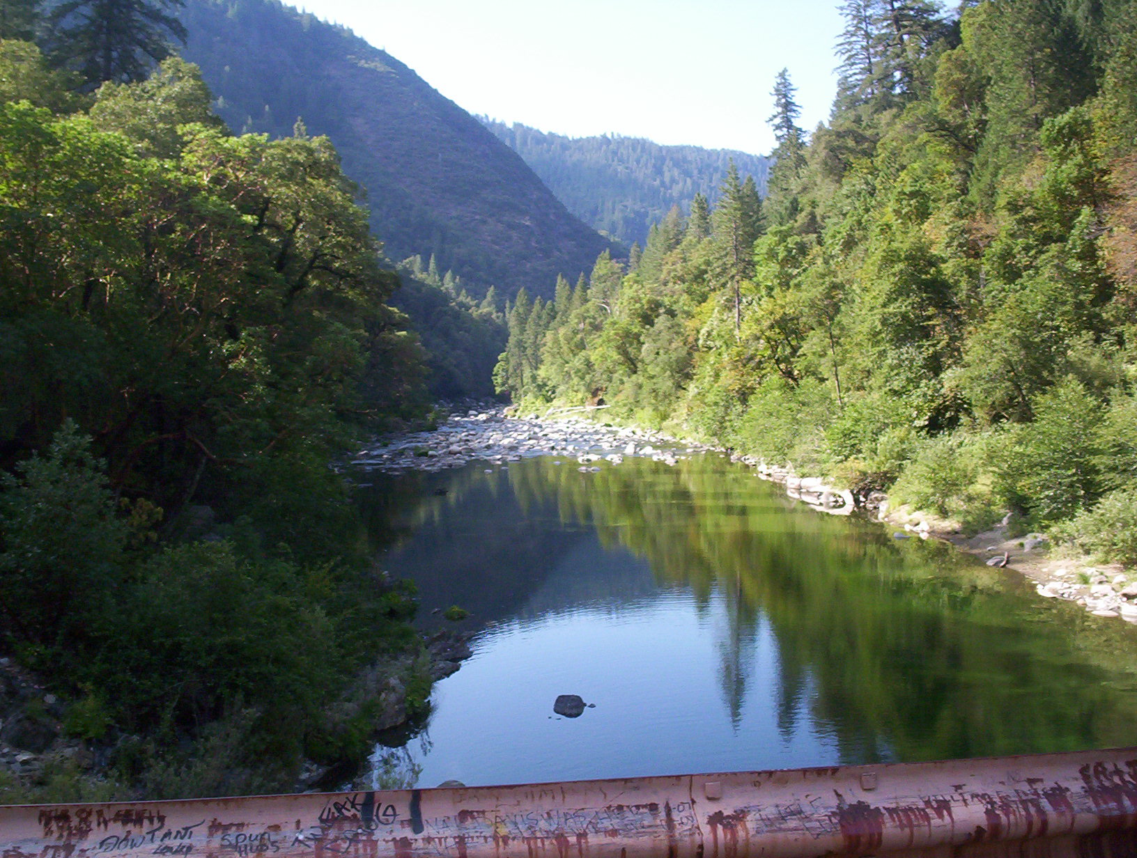 Butte County river with green trees lining the way