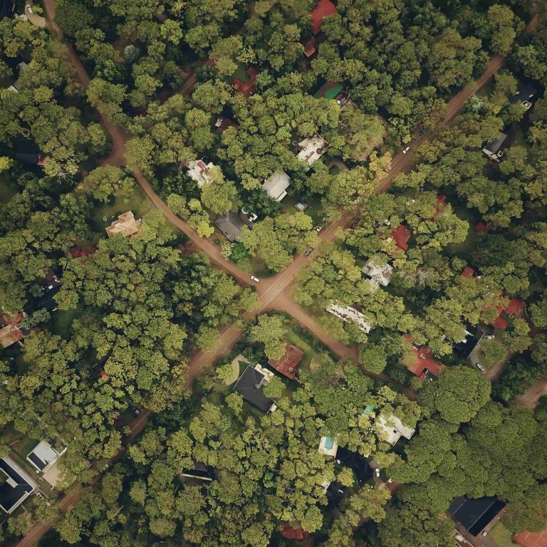 Satellite view of crossroads in a town with many trees