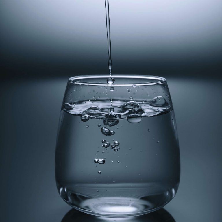 A clear glass of water being filled