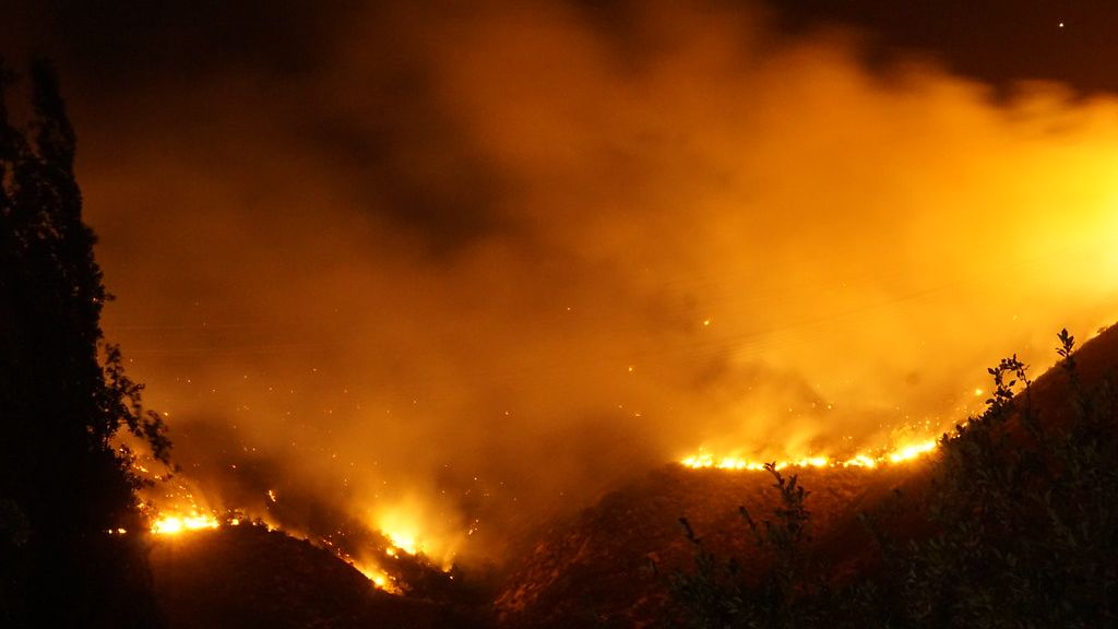 Wildfire burning down hills of homes in Chile - black and orange sky